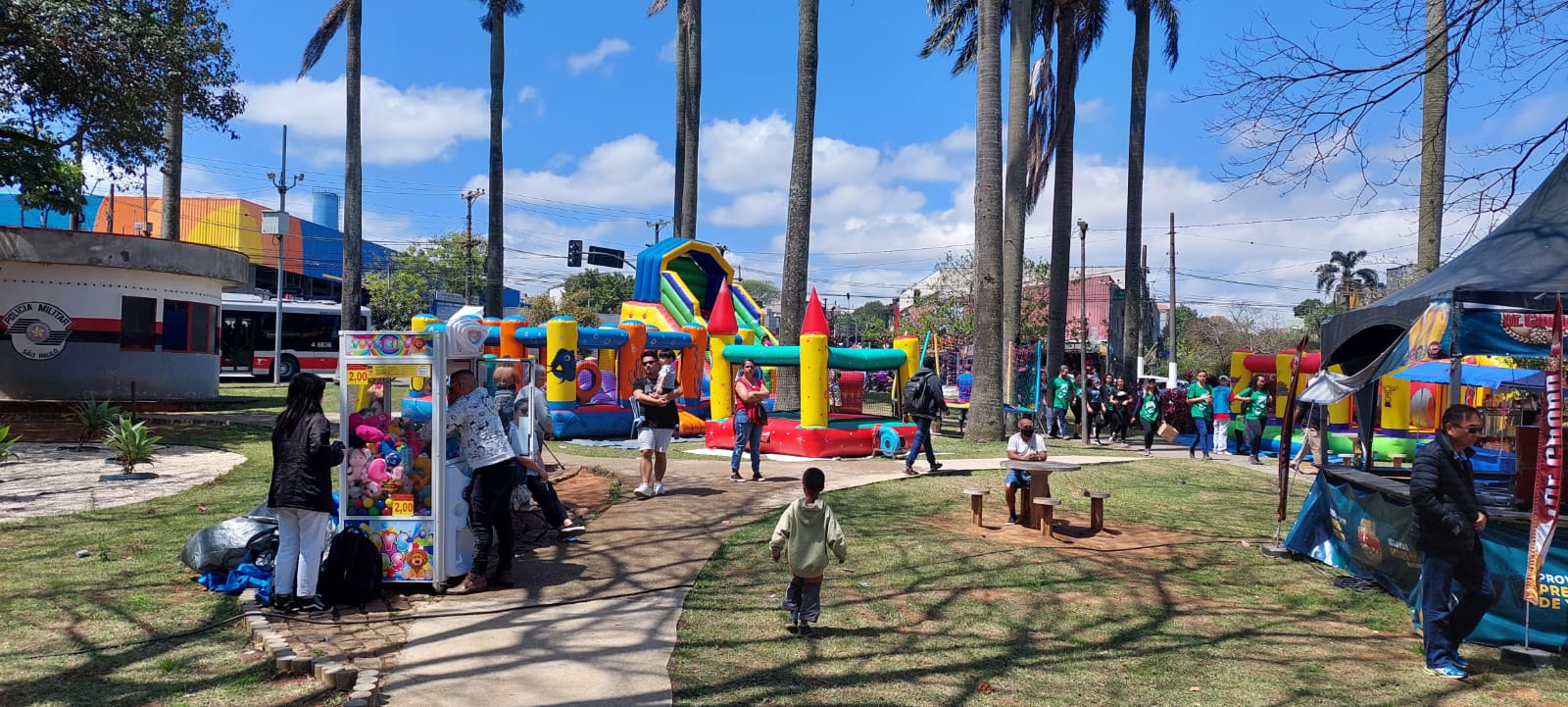 Largo de São Mateus, vários brinquedos infláveis para crianças, algumas barraquinhas de comida e várias pessoas ao redor.